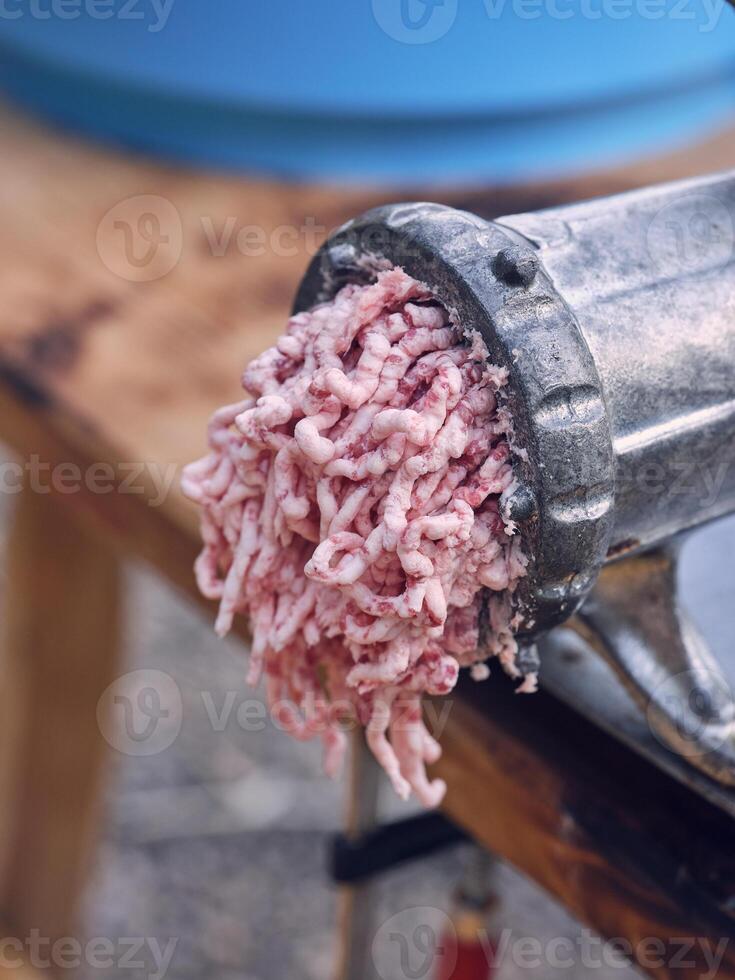 Meat grinder with mince on table in slaughterhouse photo