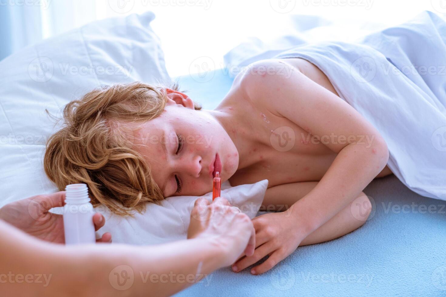 Crop mother giving medicine to sleeping son photo