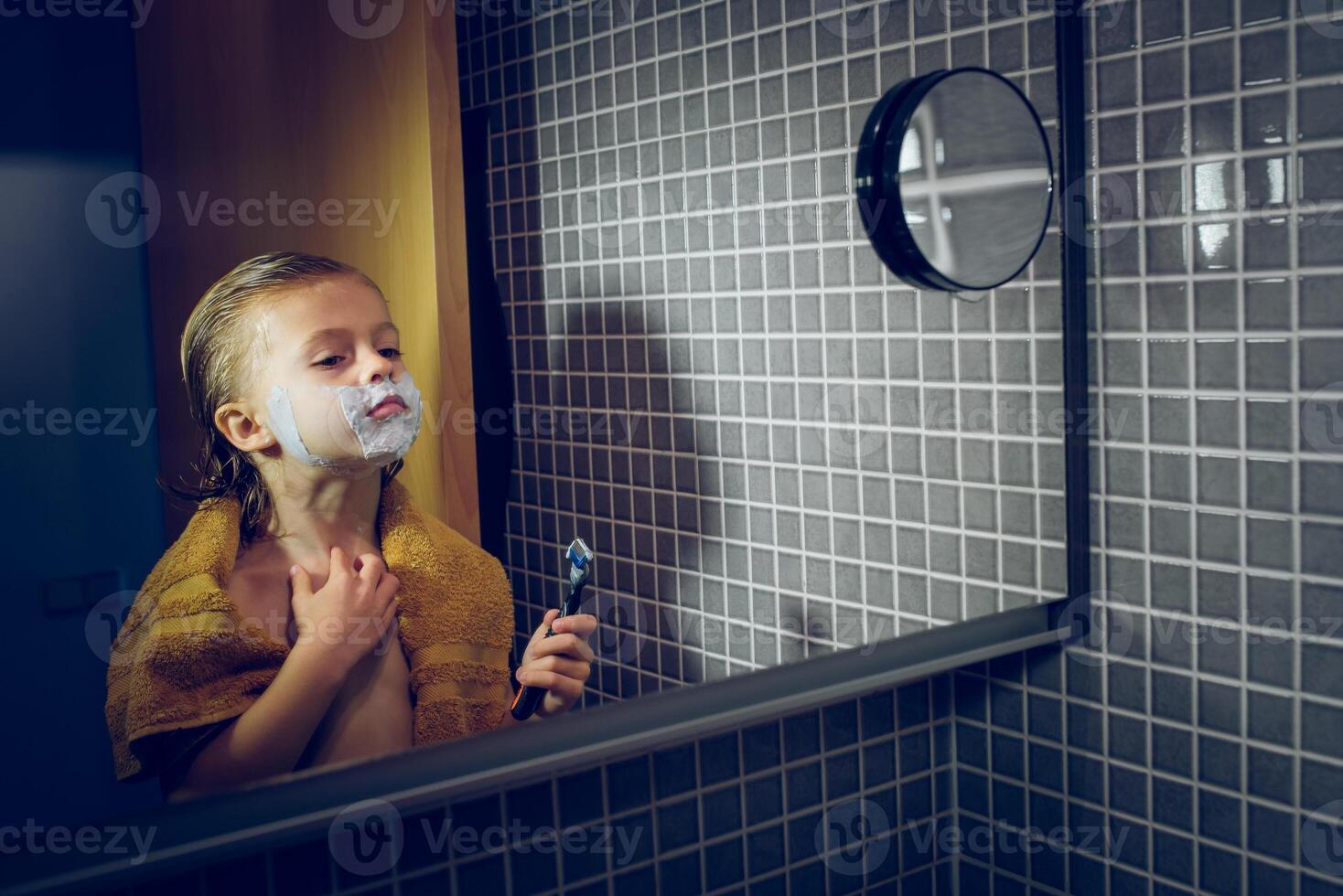 Boy shaving in bathroom with mirror photo
