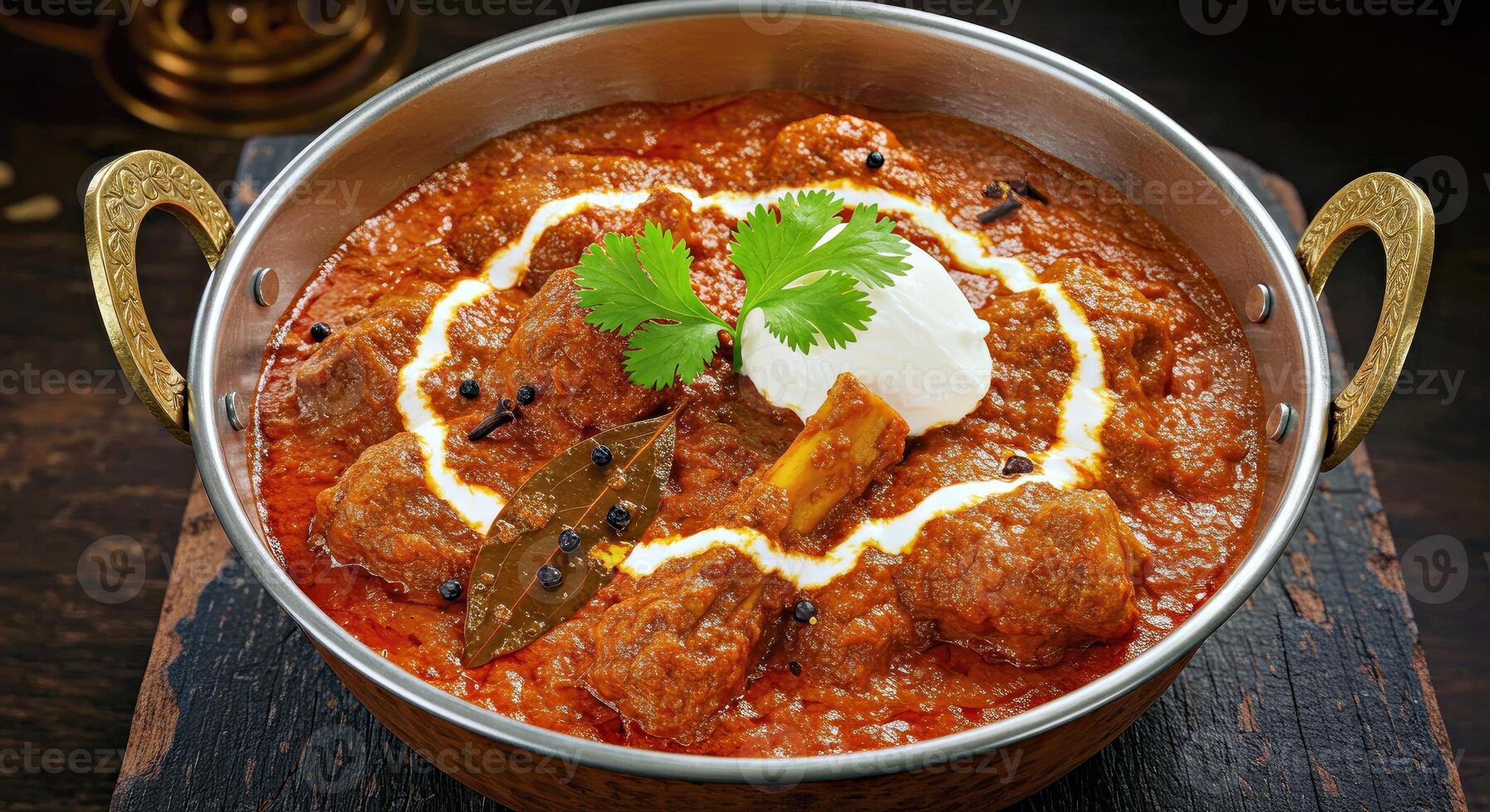 A bowl of curry with a spoon and a garnish photo