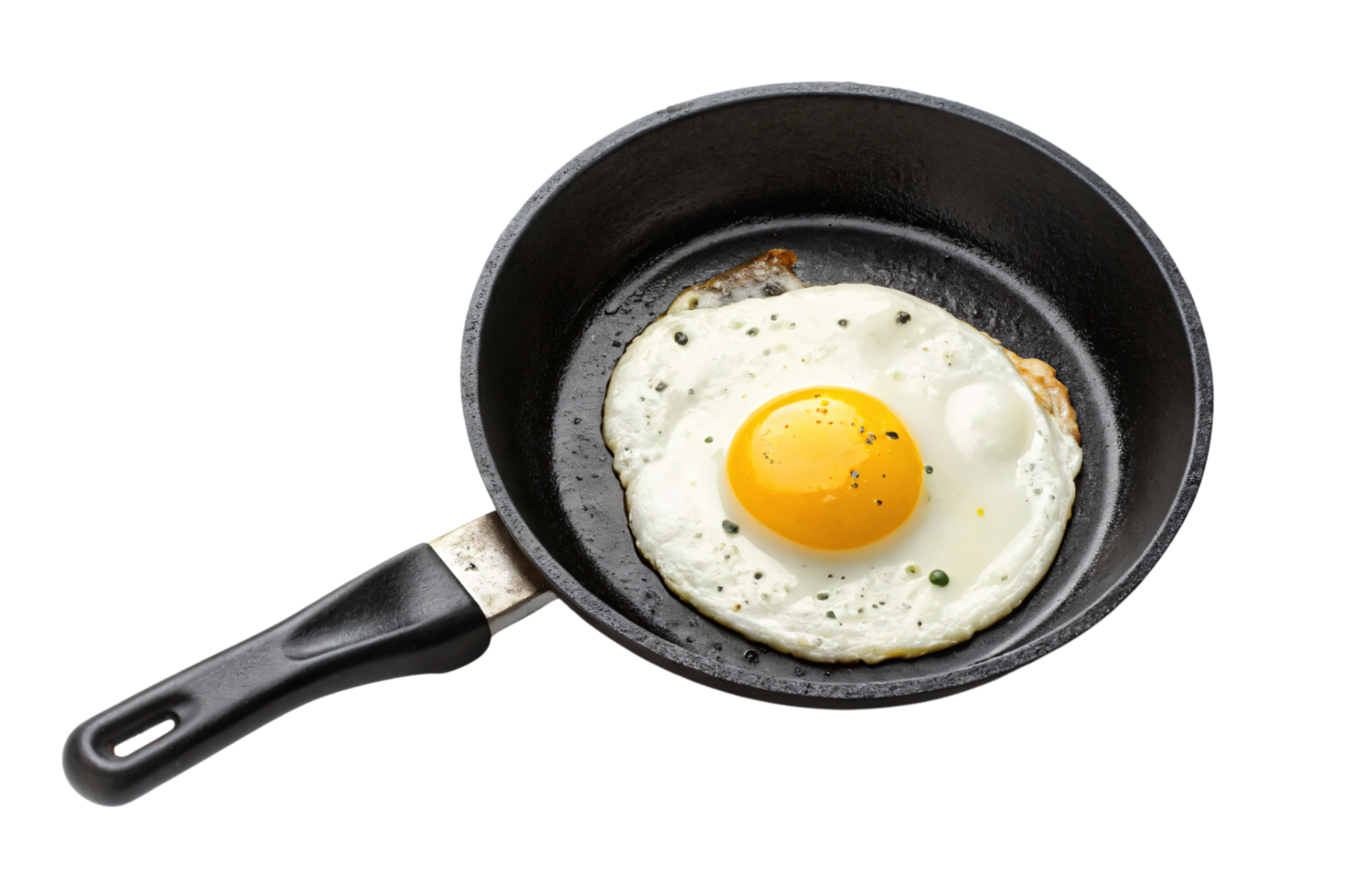 A perfectly cooked egg with a golden yolk in a black skillet, garnished with ground pepper and herbs for a simple, appetizing meal png