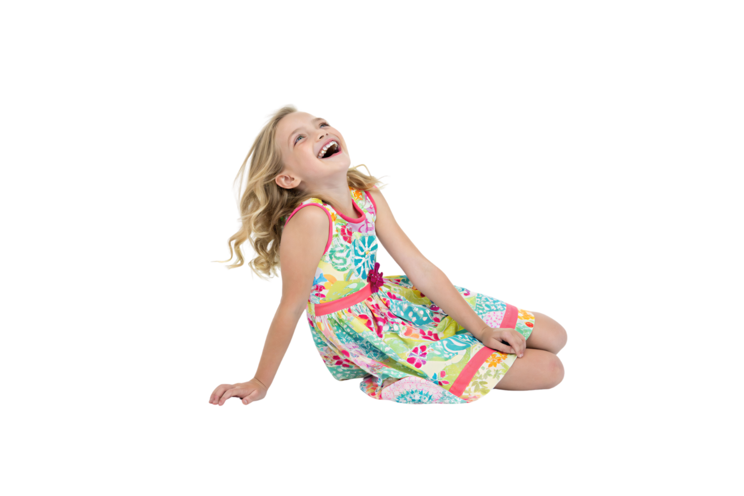 A blonde girl in a colorful floral dress sits and laughs joyously, her carefree energy and vibrant outfit radiating childhood happiness and innocence png