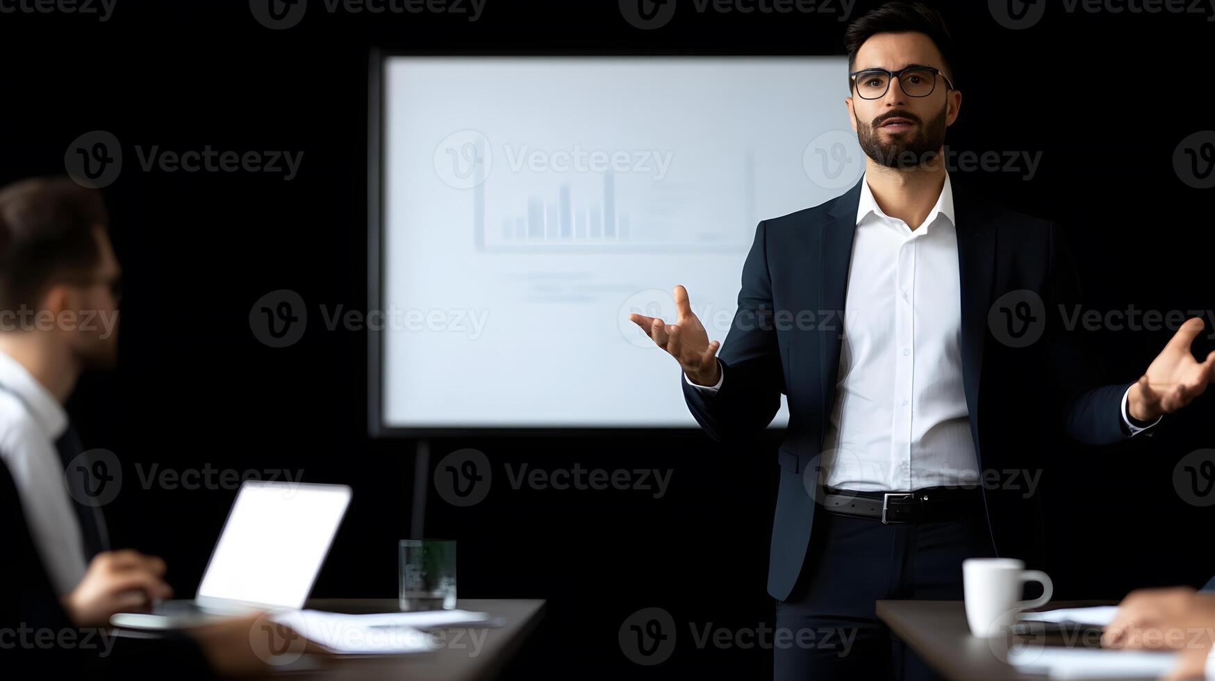 Professional businessmen in a formal meeting discussing strategies in a modern conference room with a whiteboard and laptops photo