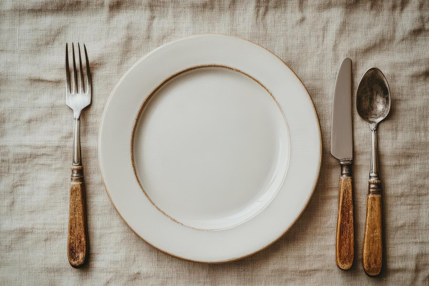 An empty plate with a fork and knife on top photo
