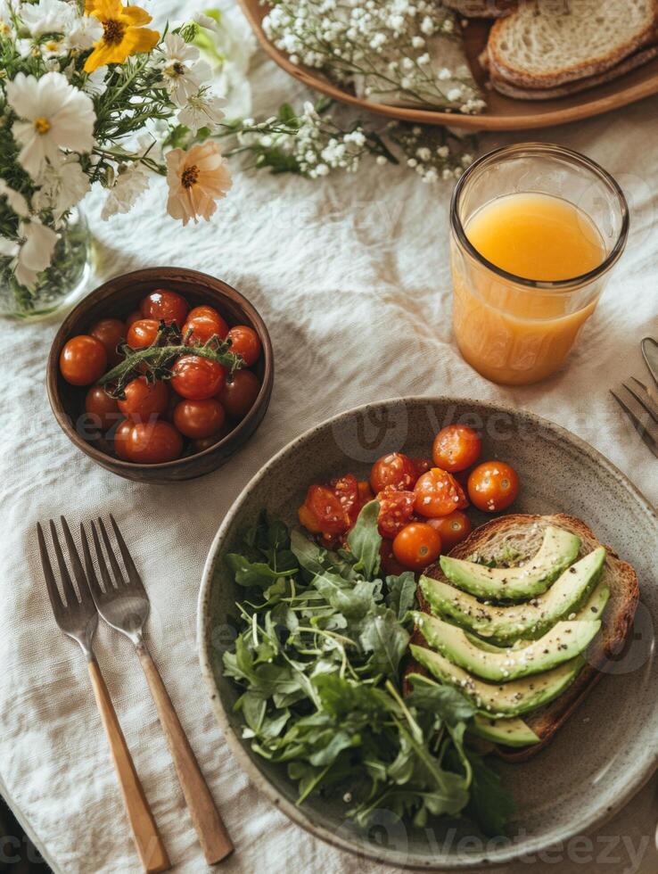 Fresh avocado toast with cherry tomatoes and arugula, served with orange juice. vibrant and healthy breakfast option, perfect for sunny morning photo