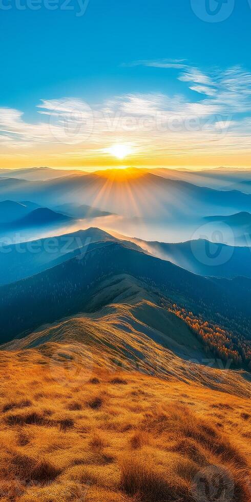 Breathtaking sunrise over rolling mountains, with golden grass and misty valleys. vibrant colors create serene and peaceful atmosphere, perfect for nature lovers photo
