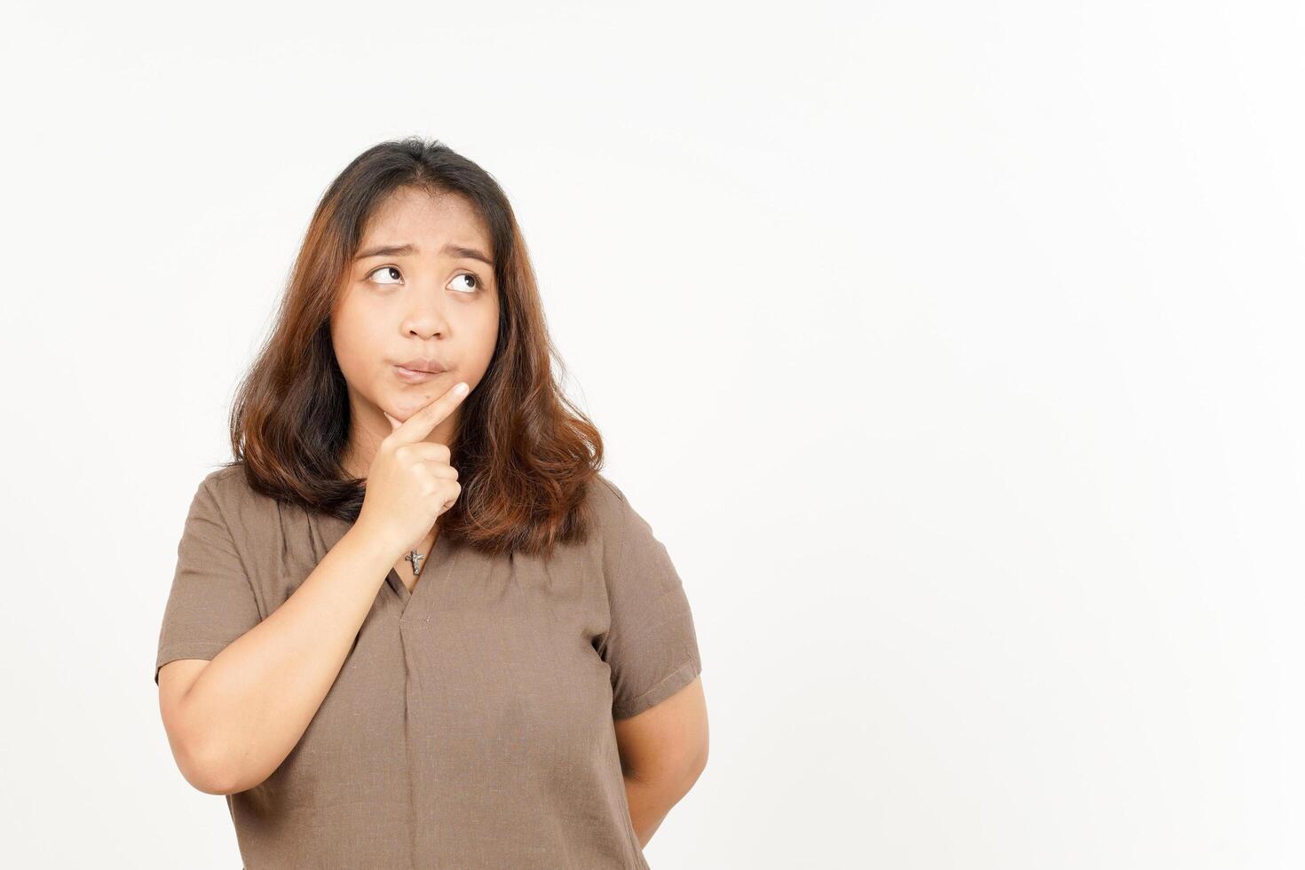 A woman is looking at something with her hand on her chin photo