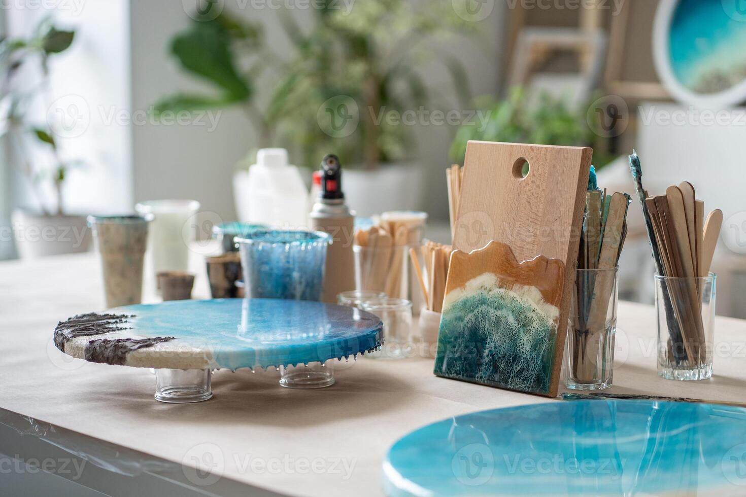 Artist workbench creating paintings artworks from epoxy resin. Table equipped for creative work. photo