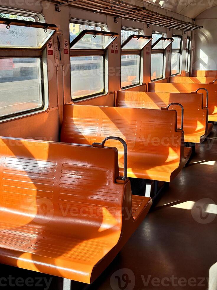 Vintage electric train car with orange seats, interior design. Retro transportation style, road trip photo