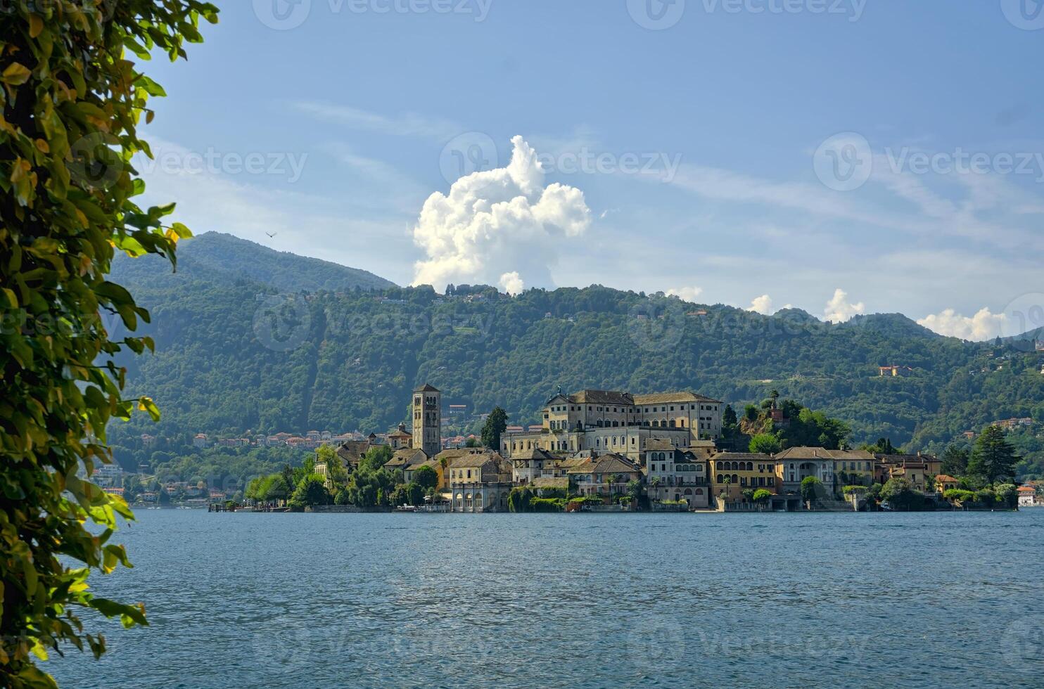 A breathtaking view of Isola San Giulio on a beautiful summer day, with its historic Basilica rising above the shimmering waters of Lake Orta. photo