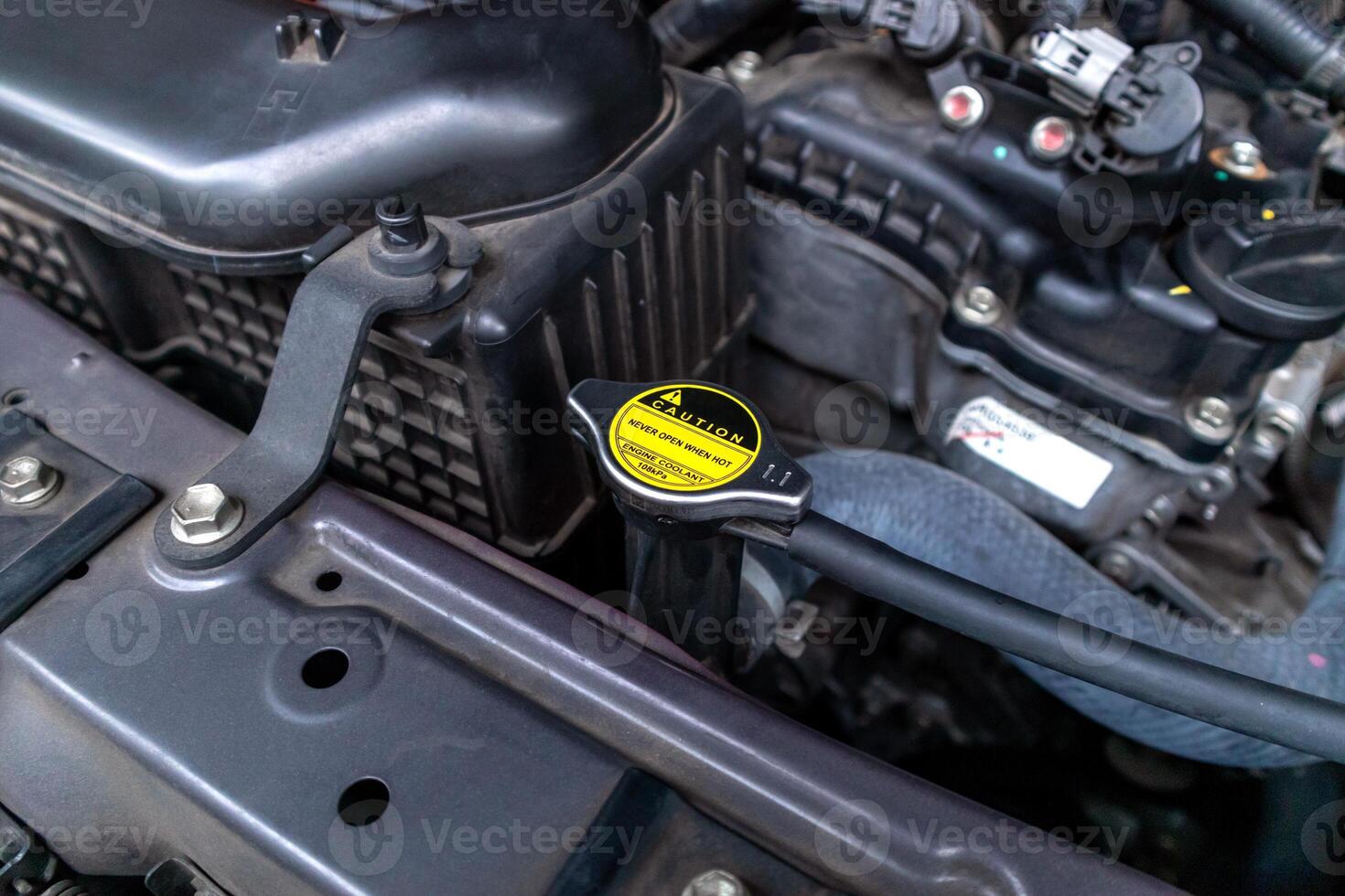 A car radiator cap with warning sticker Never open when hot photo
