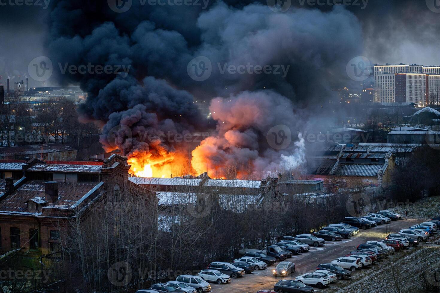 Blackened house burning on outskirts of city, smoke rising high into sky in residential city area photo