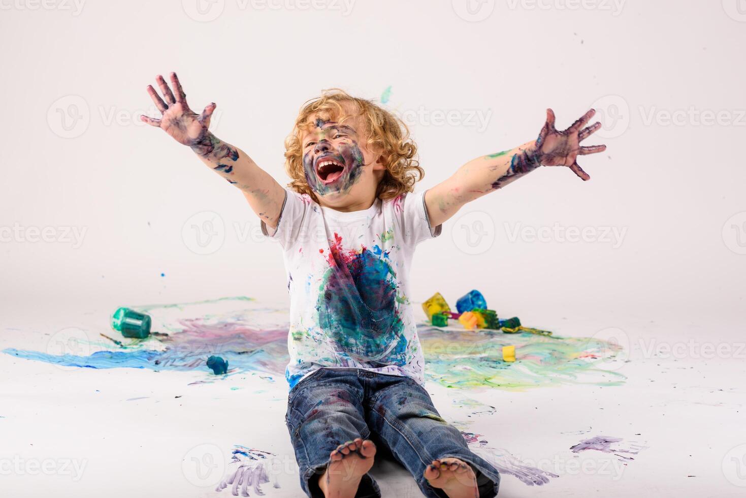 Excited boy covered with paints in studio photo