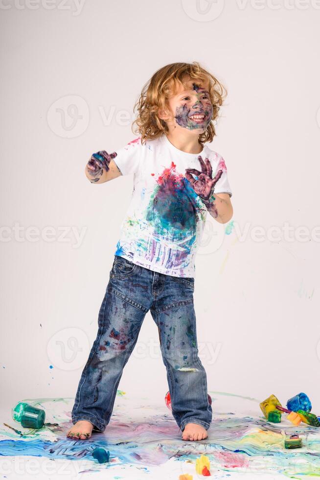 Delighted boy covered with paints in studio photo