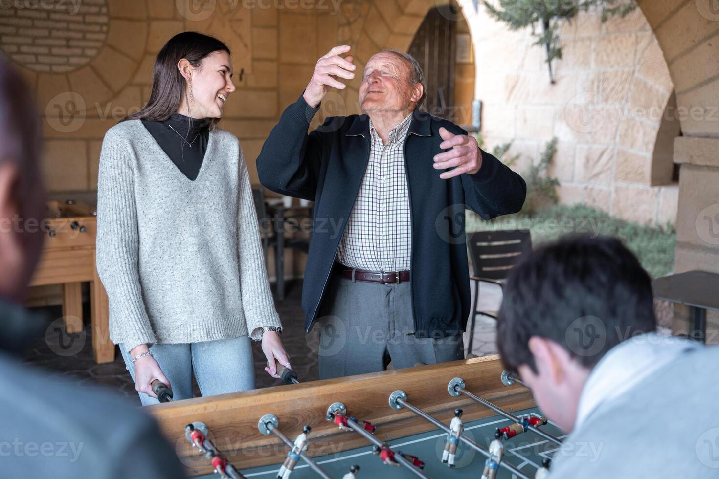 A granddaugther and grandfather are having fun after being scored in table football photo