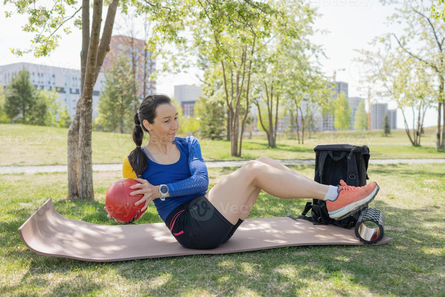 Athletic young woman in sportswear doing exercises with a ball photo