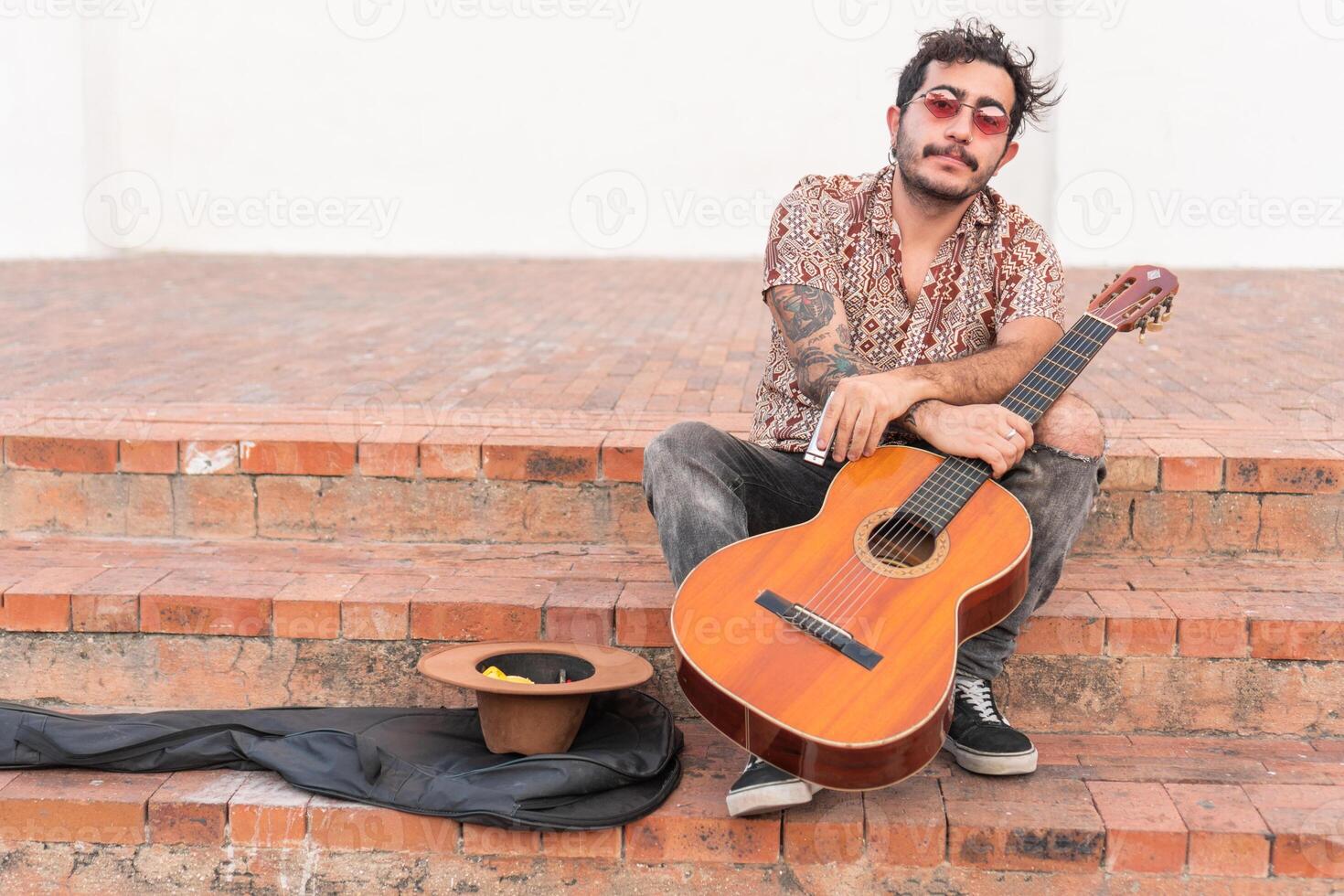 Portrait of latin musician sitting on stairs photo