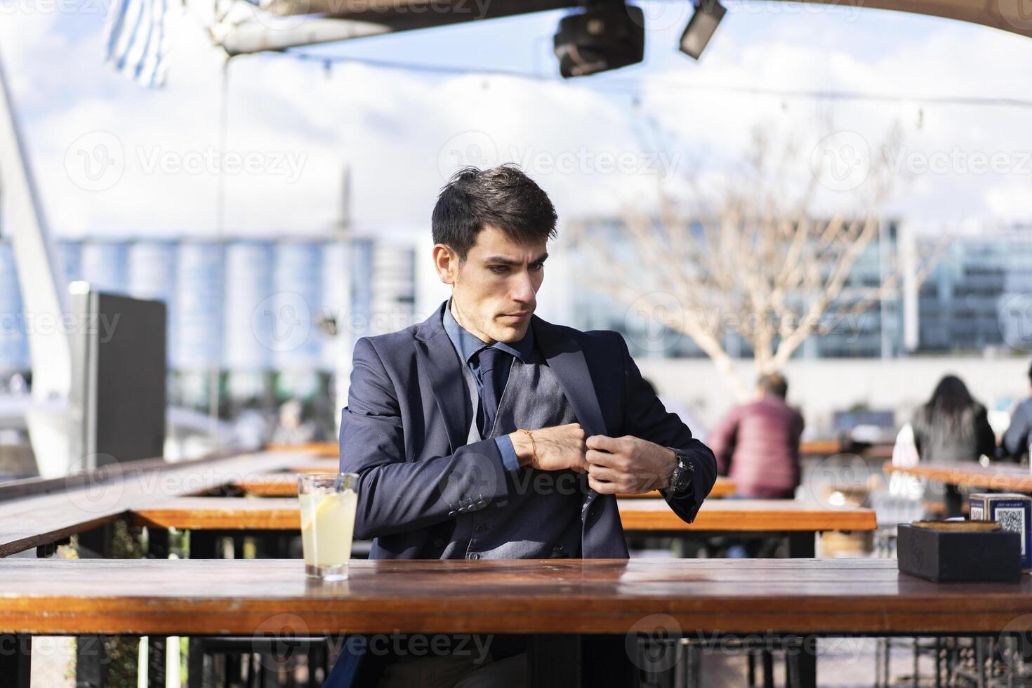 A pensive man looking for his smartphone in his pocket to check something photo