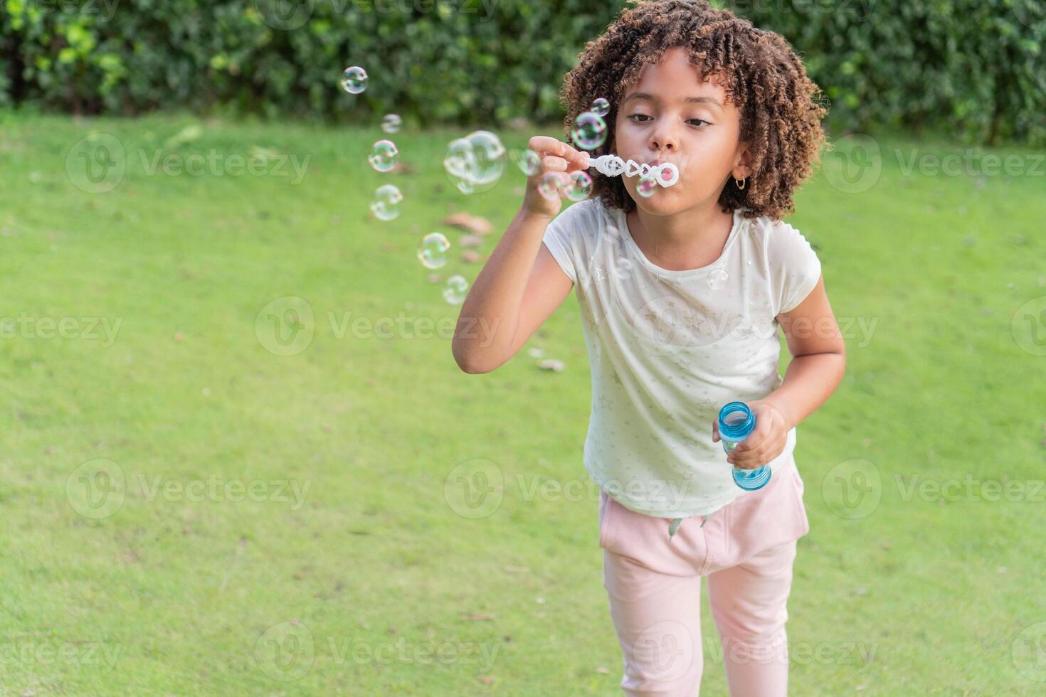 Girl blowing soap bubbles in the open air photo