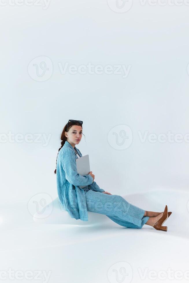 Woman with laptop in studio photo