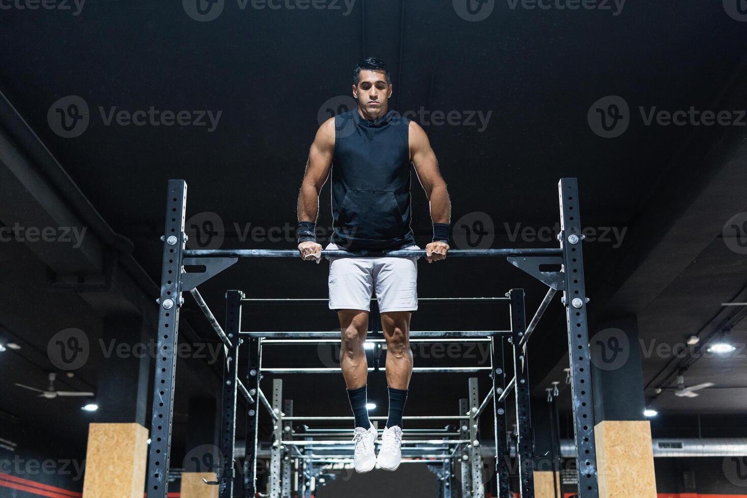 Hispanic sportsman exercising on crossbar photo