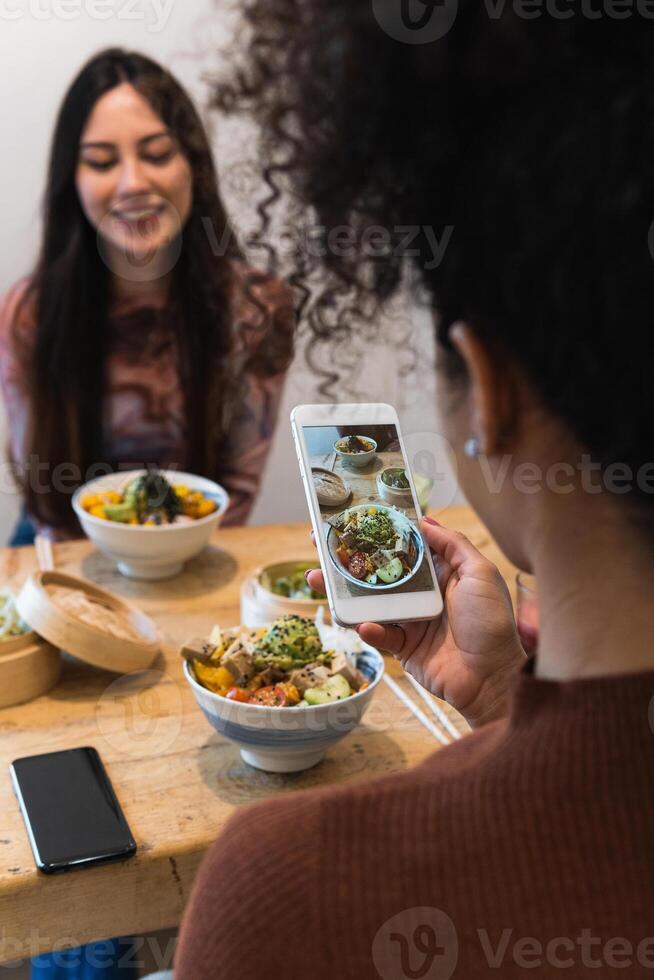 Woman taking photo of dish in restaurant