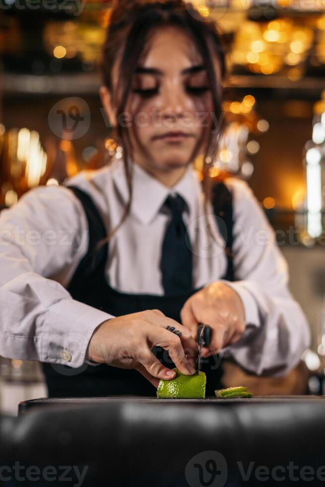 Bartender cutting limes to prepare cocktails photo