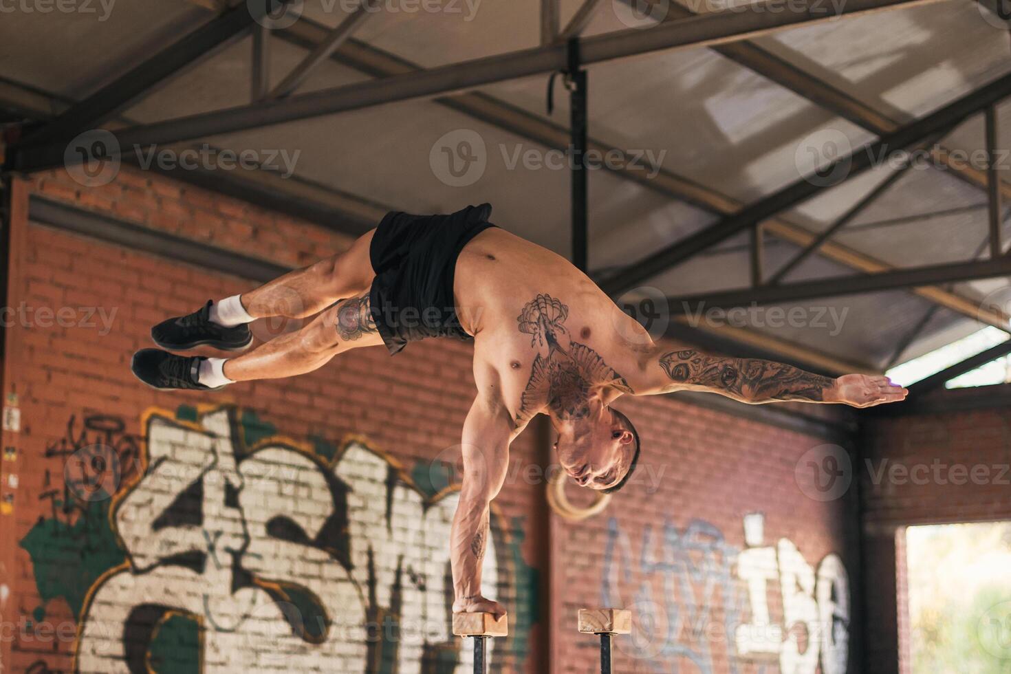 male athlete doing one hand handstand photo