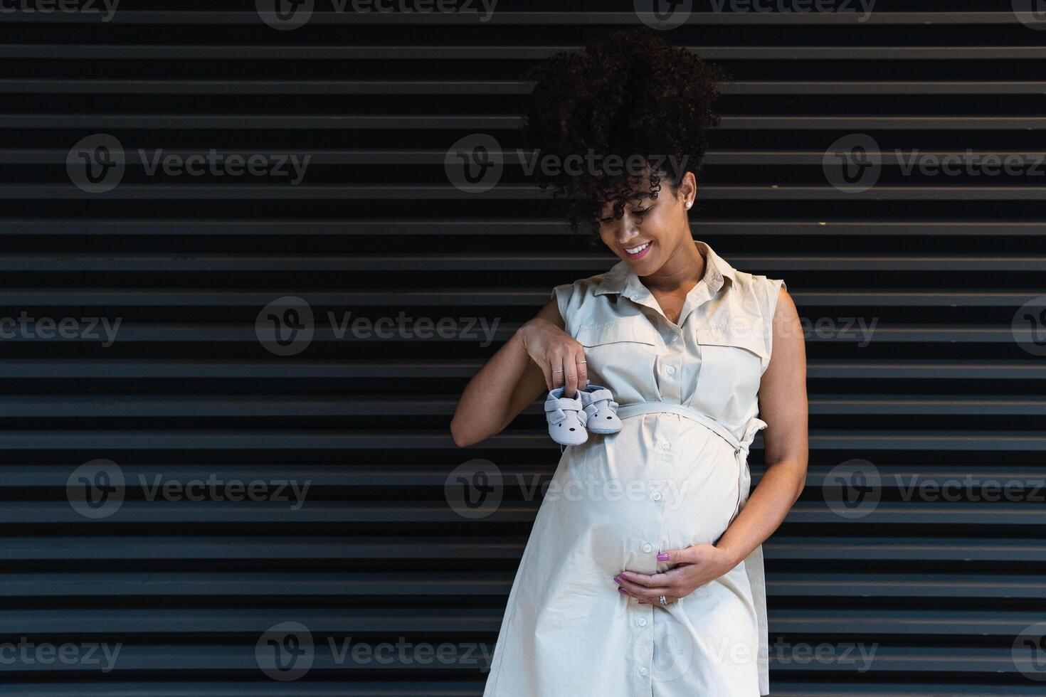 Smiling black woman showing baby booties photo