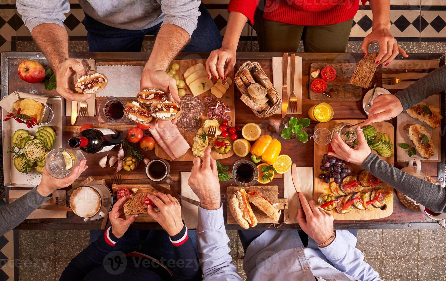 Faceless people sharing assortment of snacks photo