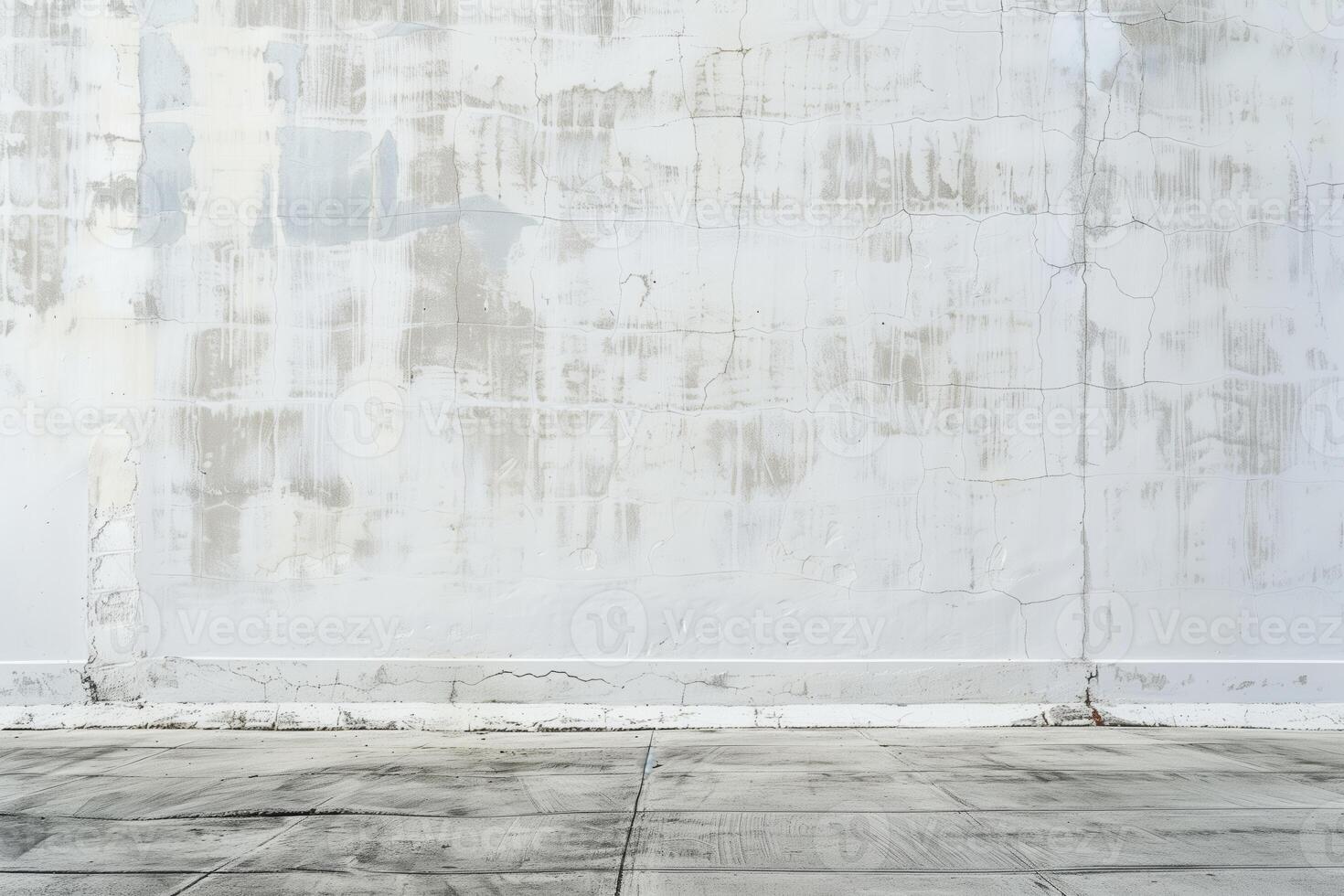 A textured, weathered white concrete wall with visible cracks and stains, complemented by a concrete floor. Ideal for backgrounds or minimalist designs. photo