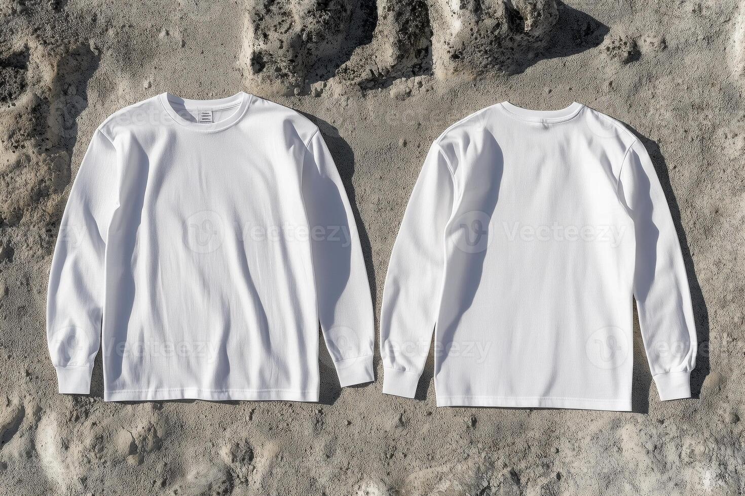Two white long - sleeved t - shirts on a rock surface photo