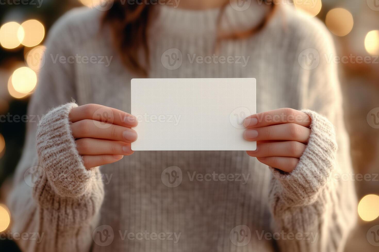 A woman holding a blank card in front of a christmas tree photo