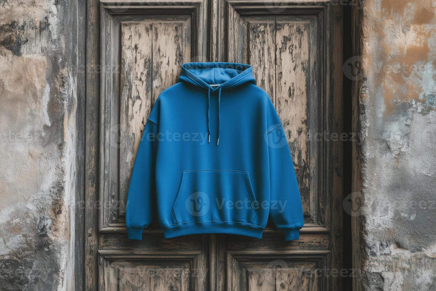 A blue color hoodie mockup against a rustic wooden door background, showcasing its casual style and texture. Sweatshirt with hood long sleeve for print. photo
