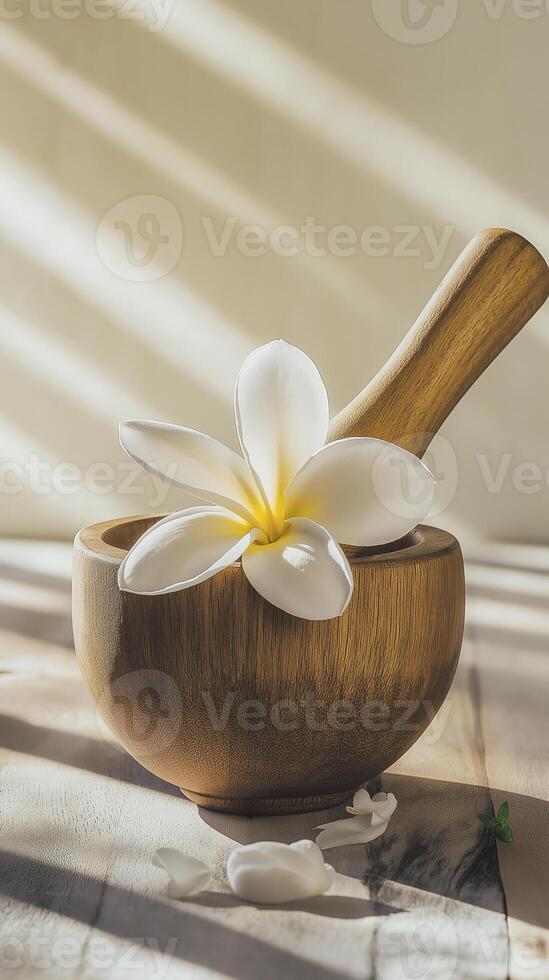 wooden mortar and pestle with white frangipani flower, creating serene and natural atmosphere photo