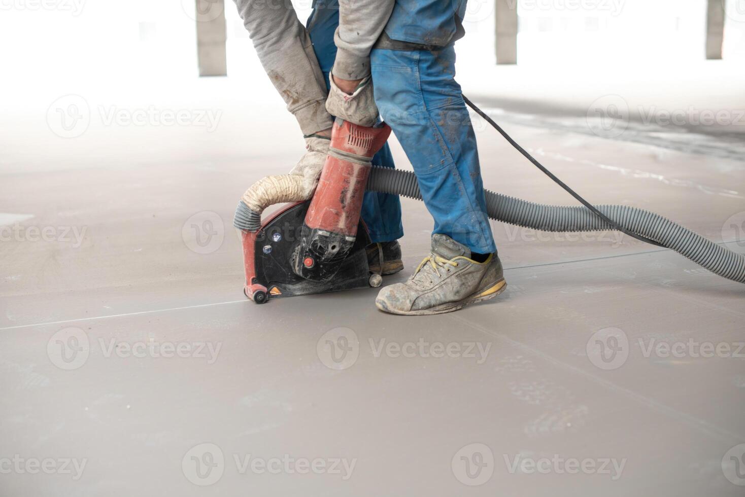 Crop anonymous man leveling floor with machine during construction photo