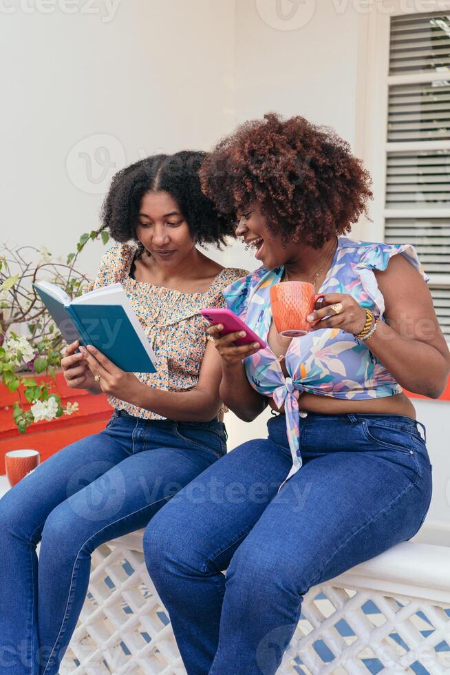 Friends smiling and showing each other things over coffee photo