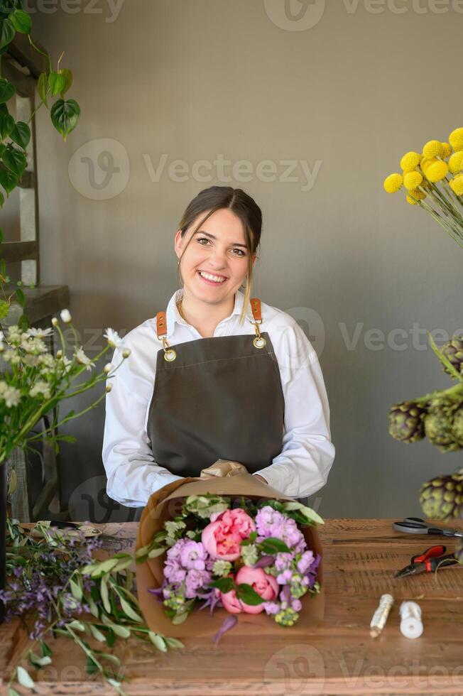 Happy woman with bouquet of flowers over table photo