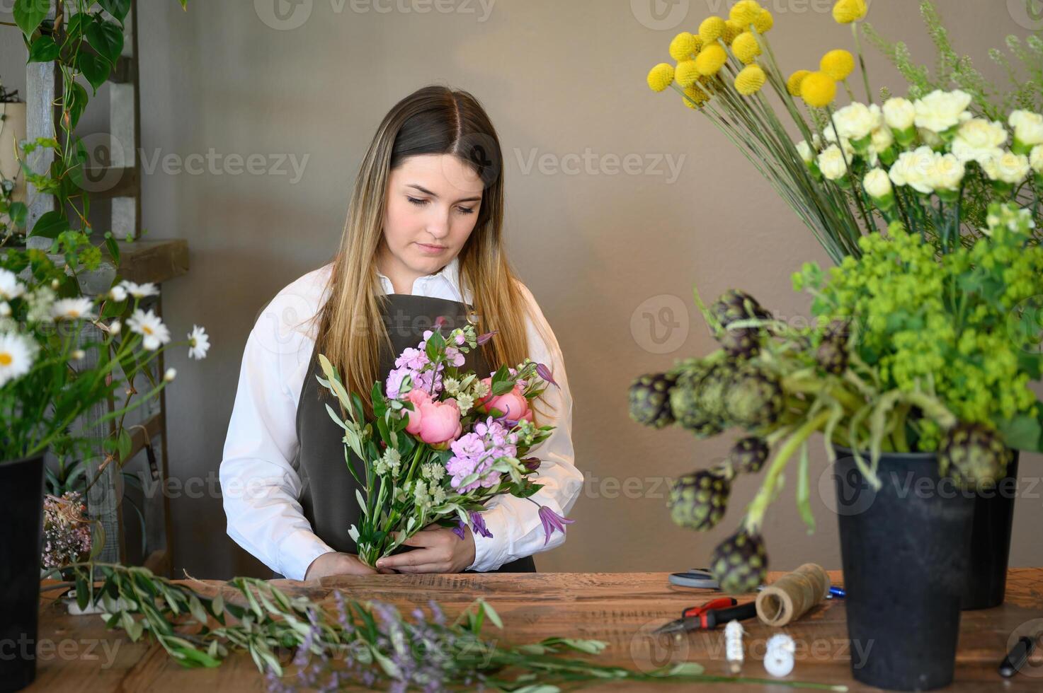 Woman making bouquet of flowers in shop photo