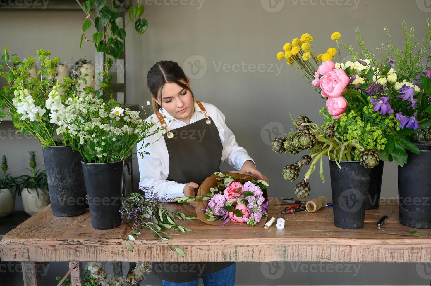 Serious woman arranging flowers in floral shop photo
