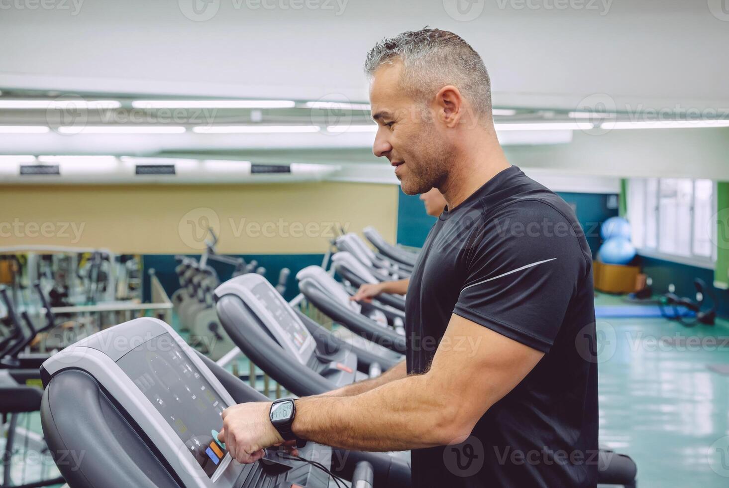 Man setting control panel of treadmill for training photo