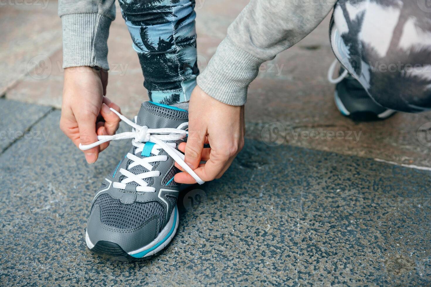 Woman runner tying her sneakers laces to training photo