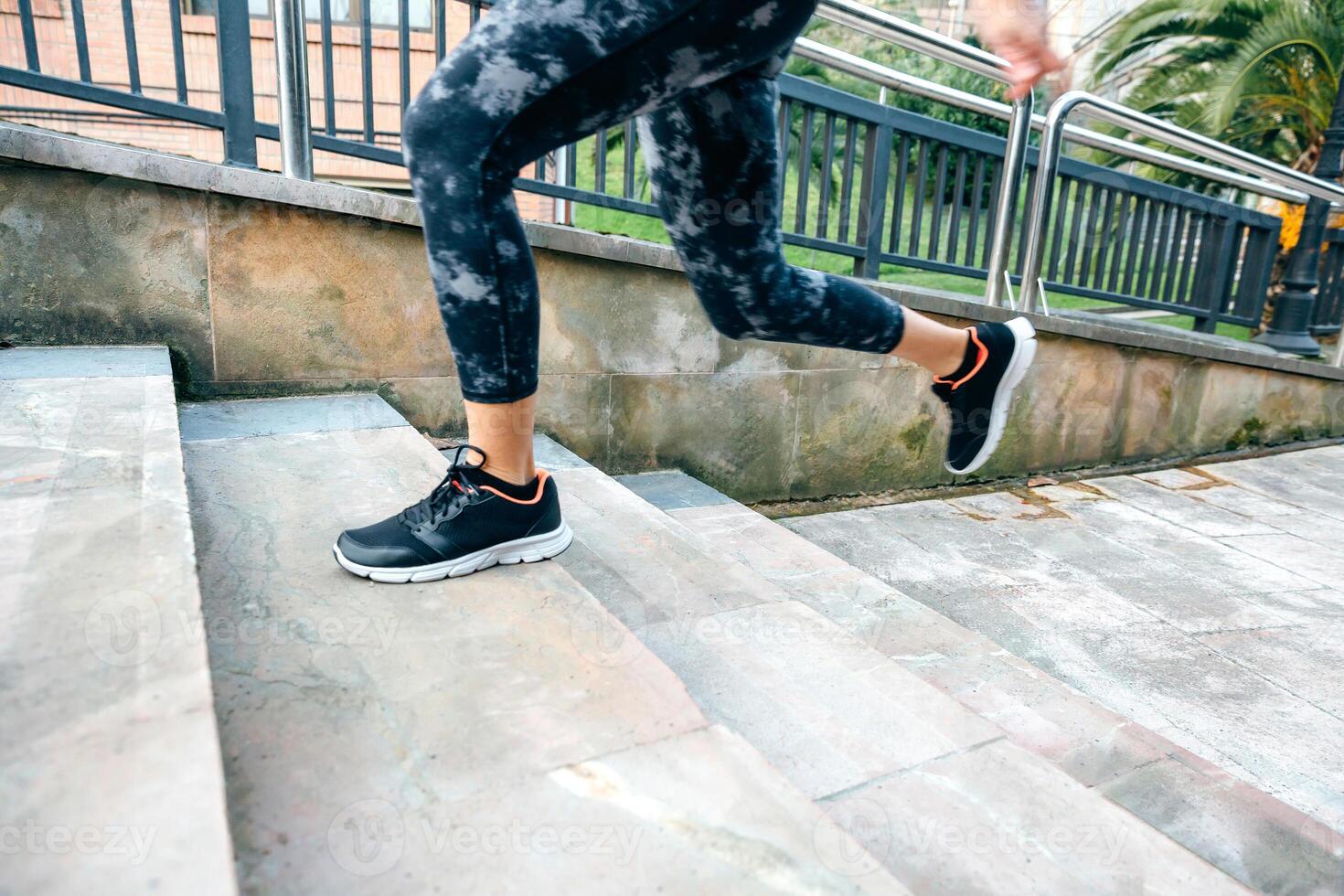 Female legs wearing leggings training running up stairs in town photo