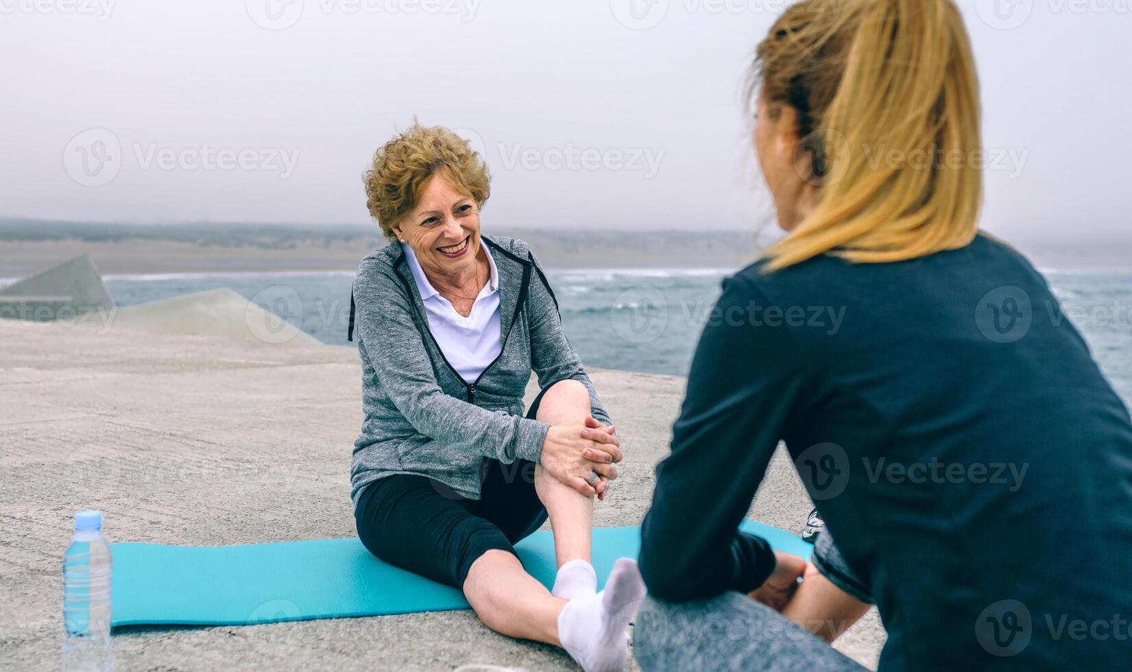 Senior sportswoman laughing with young woman photo