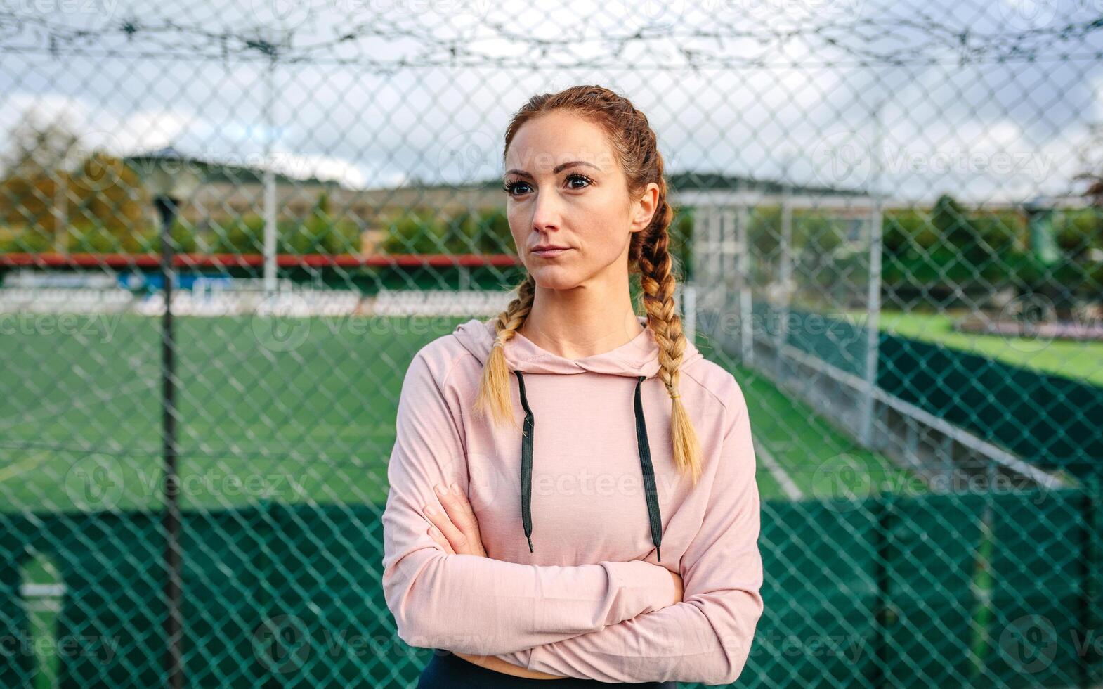 Serious sportswoman with boxer braids posing with crossed arms photo