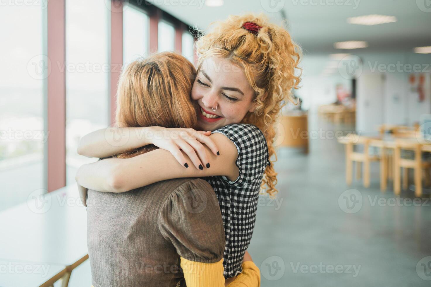 Happy teen students hugging in library photo