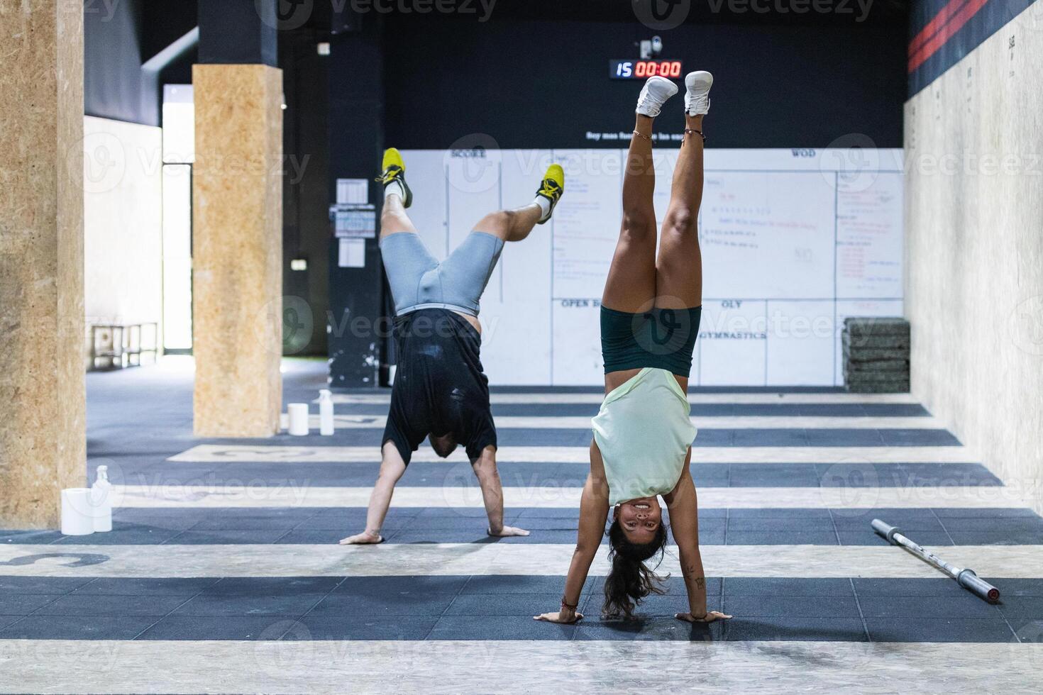 Strong ethnic athletes doing hand stand in gym photo