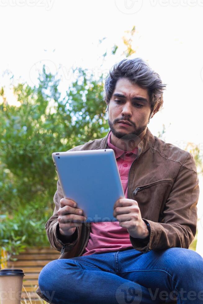 Serious man browsing tablet in city photo