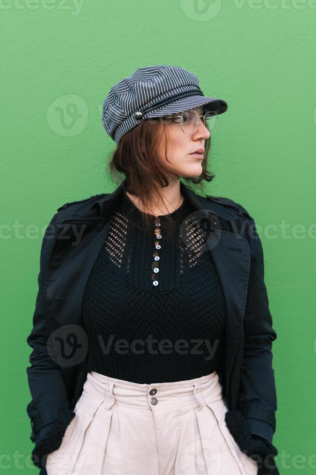 Stylish woman against green wall photo