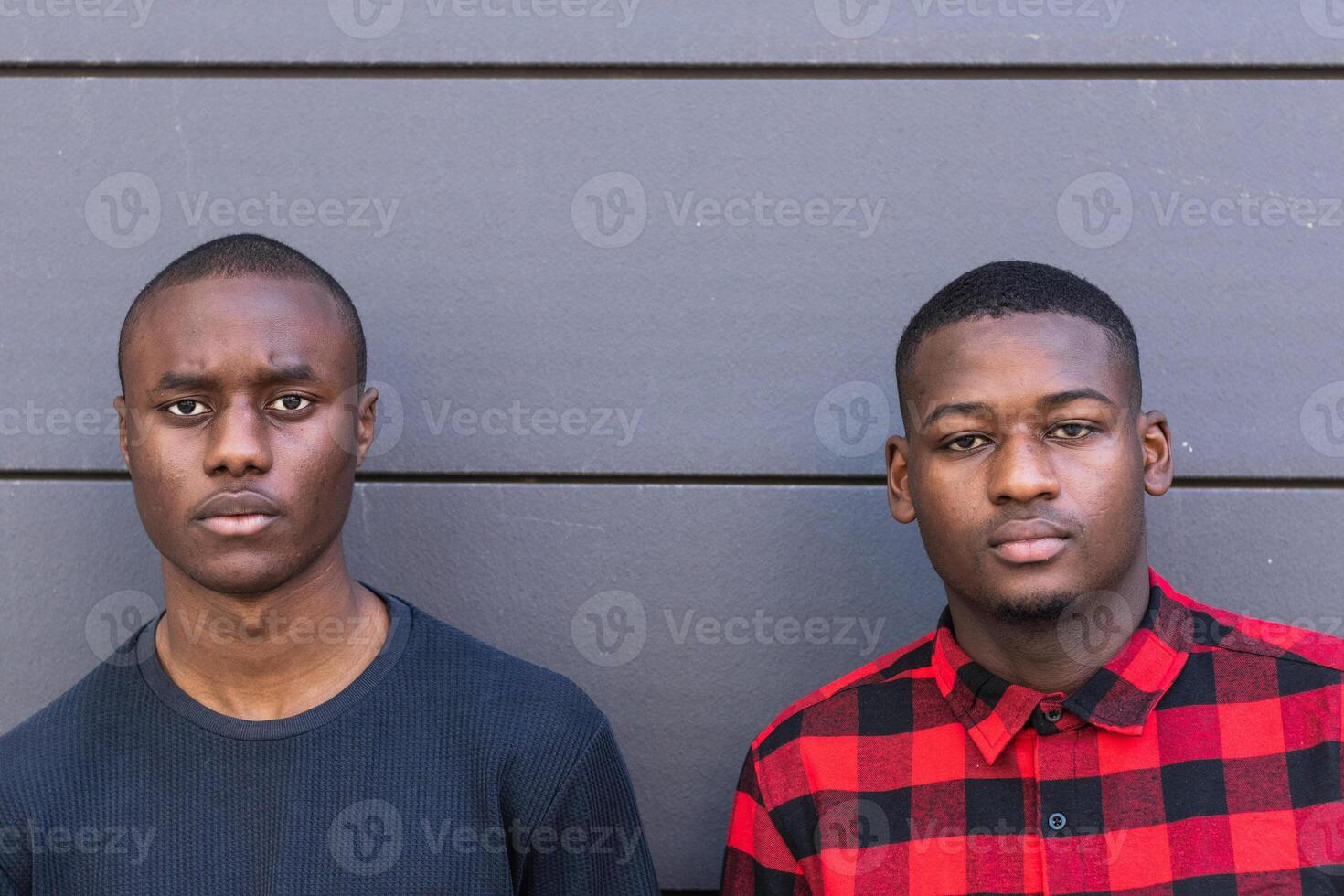Serious black male friends against gray wall photo